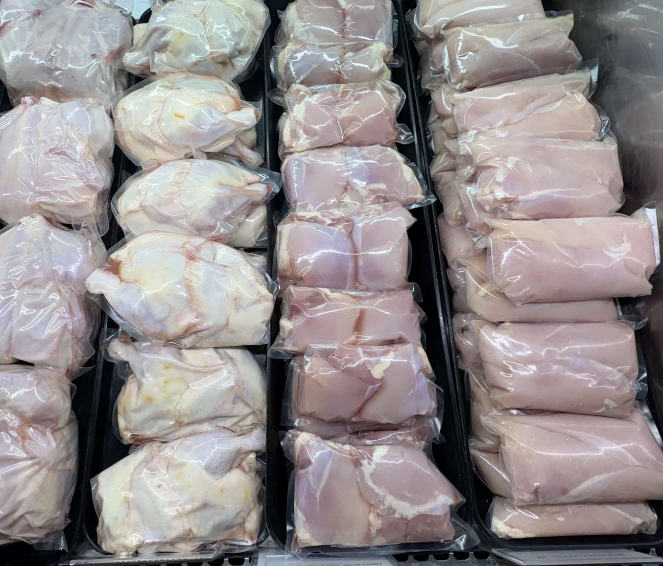 Rows of fresh chicken in sealed bags in the Plymouth Prime Meats case